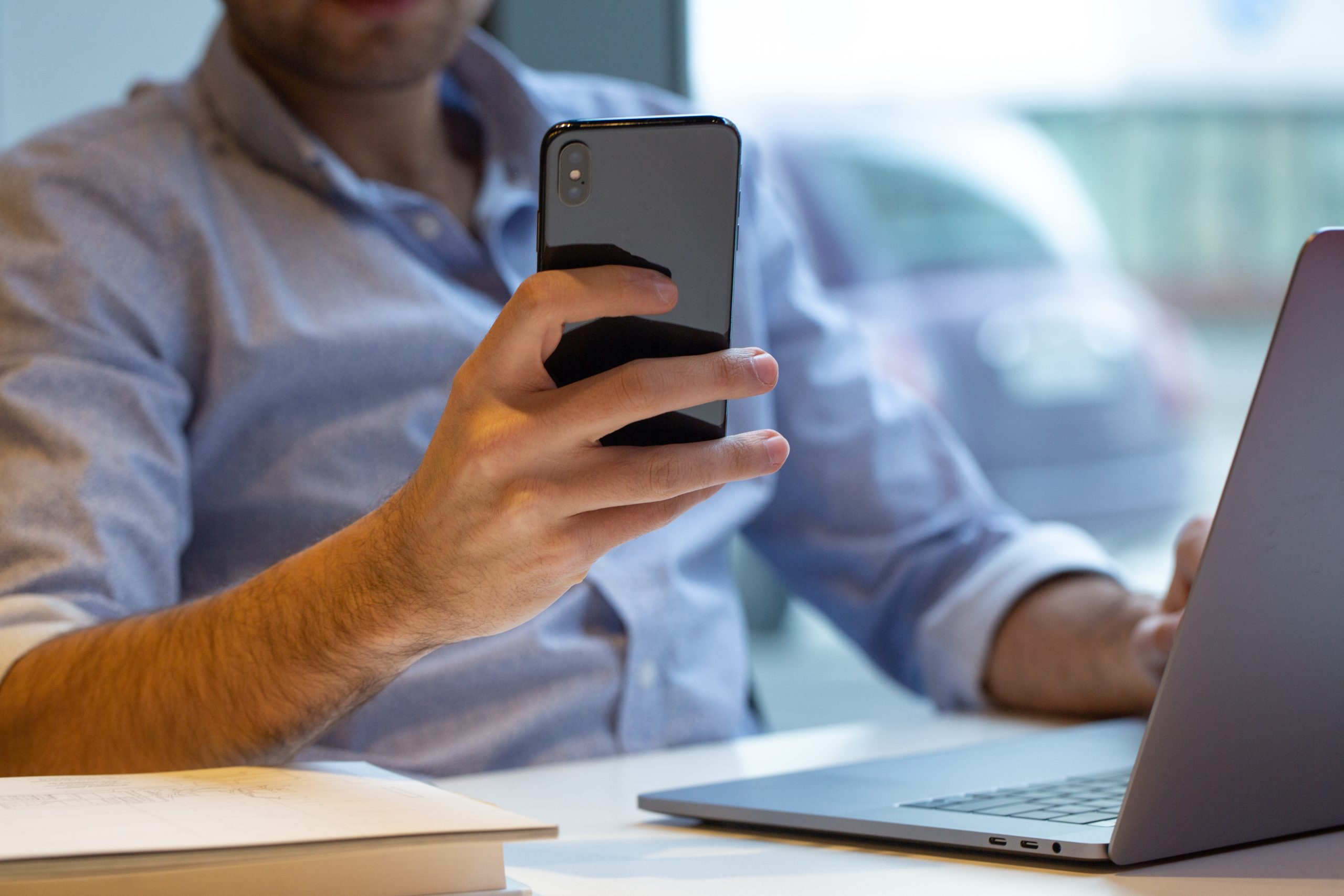 homem segurando smatphone e verificando o 0800 whatsapp