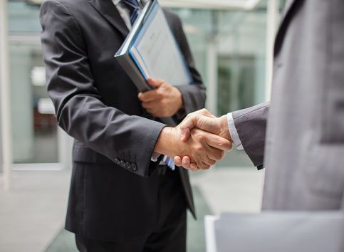 corretor de imobiliária fechando negócio com cliente homem