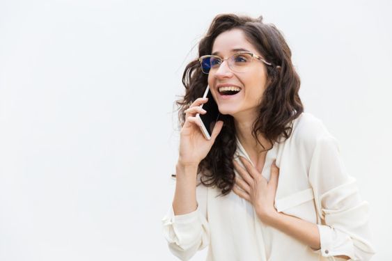 mulher feliz conversando no telefone após descobrir como ligar para outro estado