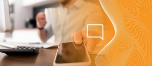 Pessoa com telefone na mão e calculador na mesa em frente dela. Representando a realização de uma auditoria sob tarifas telefônicas, reduzindo os custos indevidos