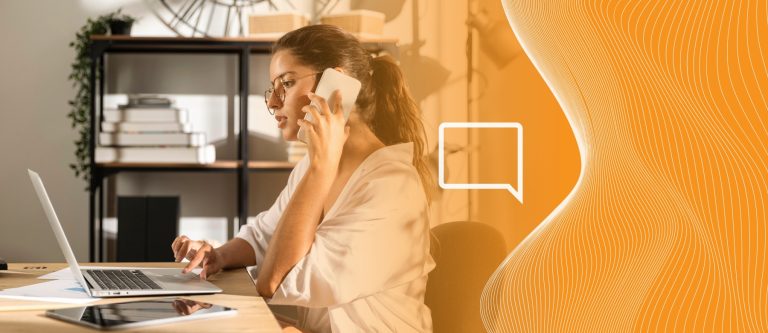 Mulher usando a tecnologia do softphone com celular e computador na mão enquanto está fora do trabalho e resolvando uma demanda do seu cargo